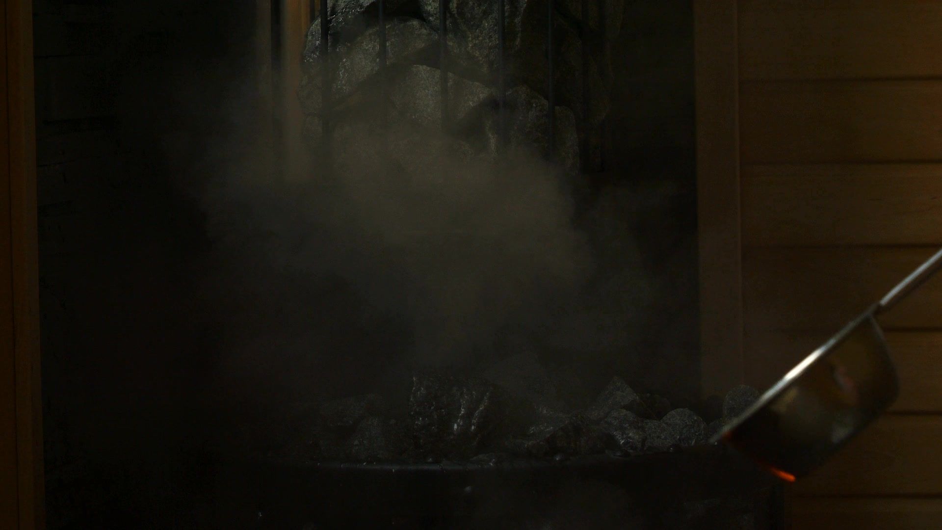 Water poured onto hot sauna stones, steam rising — the löyly moment